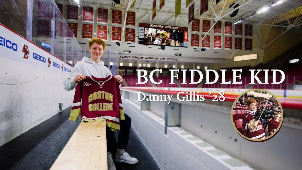 Dan Gillis holding a BC hockey jersey in sitting in Kelley Rink